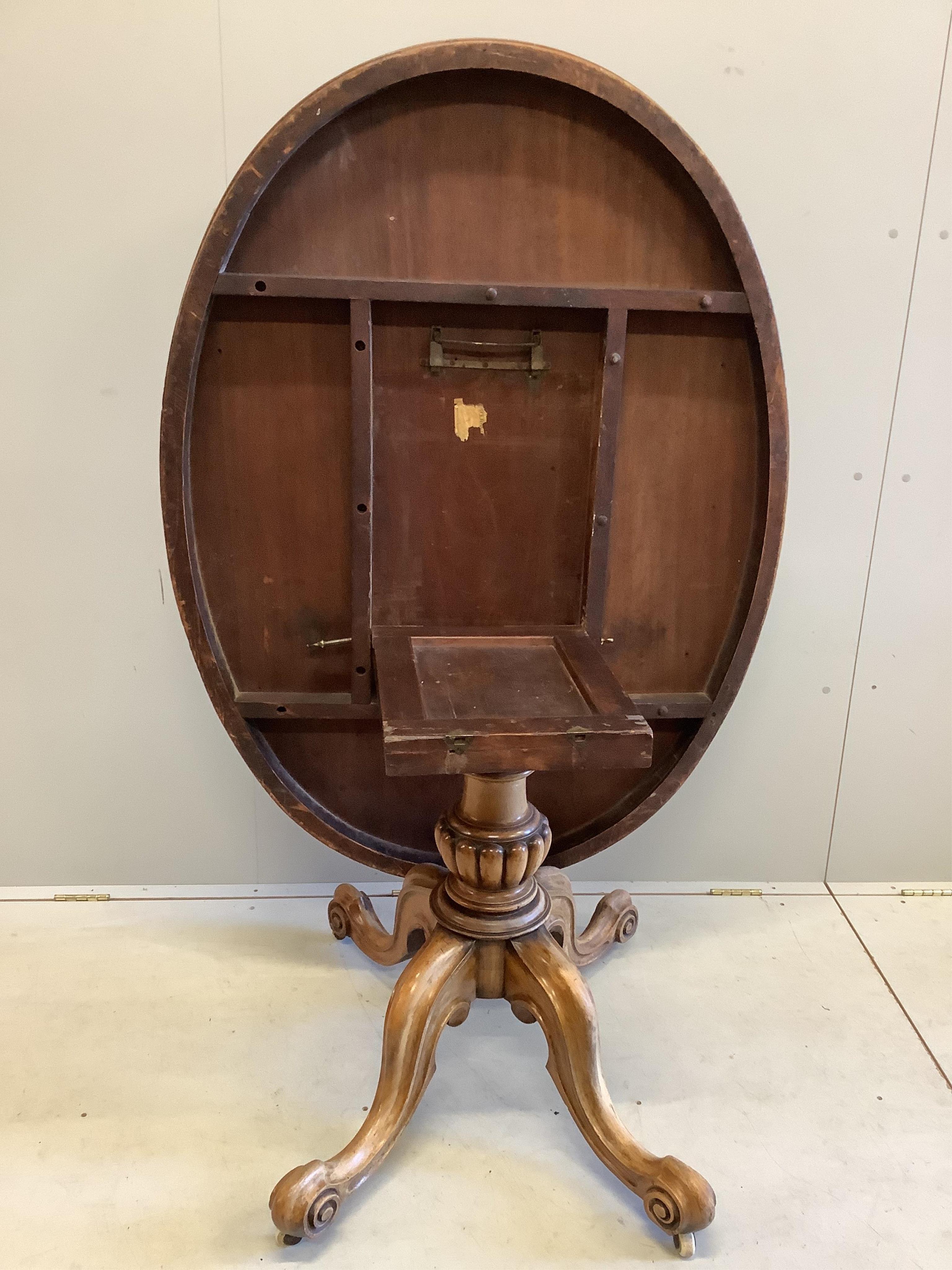 A Victorian faded mahogany oval tilt top loo table, width 137cm, depth 103cm, height 73cm
